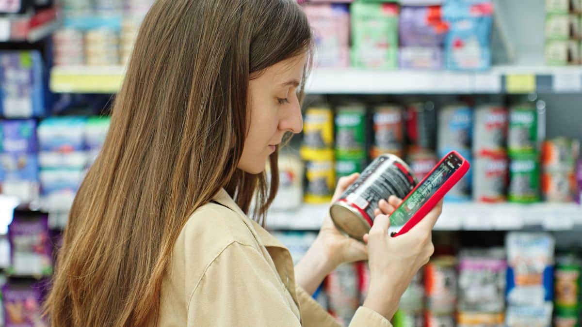 woman choosing canned cat food reading label